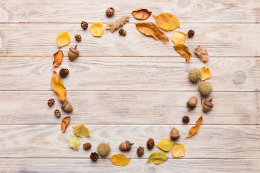 Masadaki kurumuş yapraklar, koniler ve meşe palamutlarından oluşan sonbahar kompozisyonu. Düz konum, üst görünüm, kopyalama alanı.