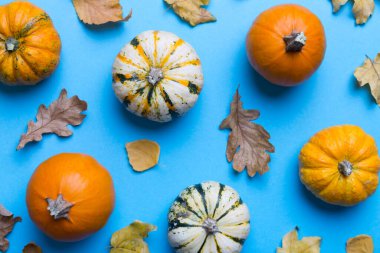 Sonbahar kompozisyonu. Masadaki kurumuş yapraklar ve diğer tasarım aksesuarlarından oluşan desen. Düz yatış, üst görünüm.