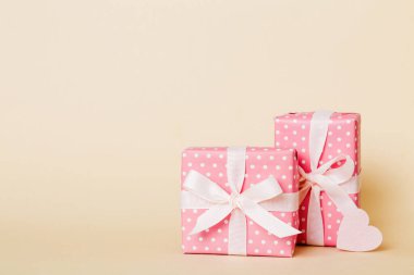 gift box with red bow and red heart on colored background. Perspective view. Flat lay.
