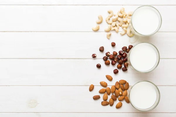 Set or collection of various vegan milk almond, cashew, on table background. Vegan plant based milk and ingredients, top view.