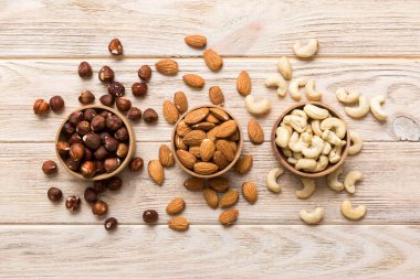 Renkli masadaki ahşap kasede fındık çeşitleri. Ceviz, fındık, ceviz, badem. Fındık Üst görünümü ile kopyalama alanını karıştır.