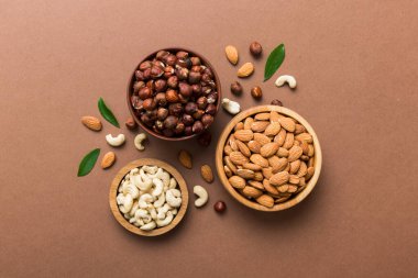 Renkli masadaki ahşap kasede fındık çeşitleri. Ceviz, fındık, ceviz, badem. Fındık Üst görünümü ile kopyalama alanını karıştır.