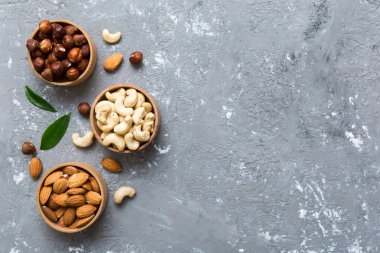 Renkli masadaki ahşap kasede fındık çeşitleri. Ceviz, fındık, ceviz, badem. Fındık Üst görünümü ile kopyalama alanını karıştır.