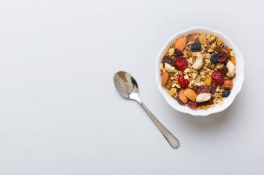 Sağlıklı bir kahvaltı hazırlıyorum. Bir kasede çeşitli kurutulmuş meyve ve fındıklı granola. Sağlıklı tatlı kavramı. Düz konum, kopyalama alanı olan üst görünüm.