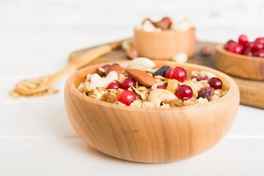 Sağlıklı bir kahvaltı hazırlıyorum. Bir kasede çeşitli kurutulmuş meyve ve fındıklı granola. Sağlıklı tatlı kavramı. Düz konum, kopyalama alanı olan üst görünüm.
