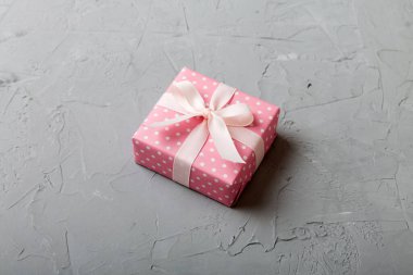 Noel 'i ya da diğer tatil hediyelerini renkli arka planda kurdeleyle renkli kağıda sardım. Şimdiki kutu, renkli tabloda hediye süslemesi, kopya alanı ile üst görünüm.