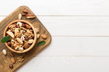 mixed nuts in bowl. Mix of various nuts on colored background. pistachios, cashews, walnuts, hazelnuts, peanuts and brazil nuts.