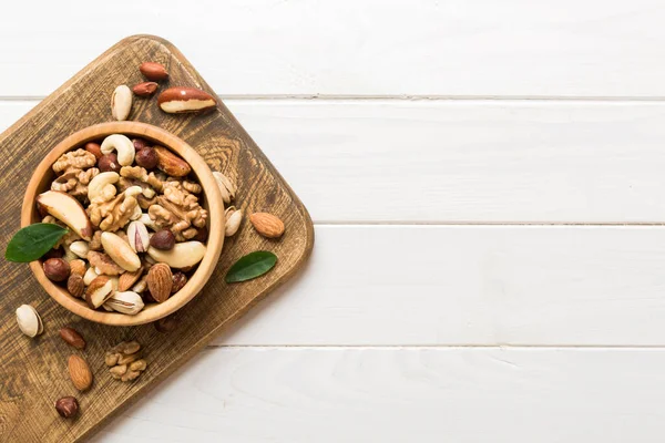 mixed nuts in bowl. Mix of various nuts on colored background. pistachios, cashews, walnuts, hazelnuts, peanuts and brazil nuts.