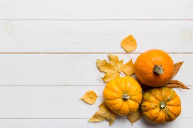 Sonbahar kompozisyonu. Masadaki kurumuş yapraklar ve diğer tasarım aksesuarlarından oluşan desen. Düz yatış, üst görünüm.