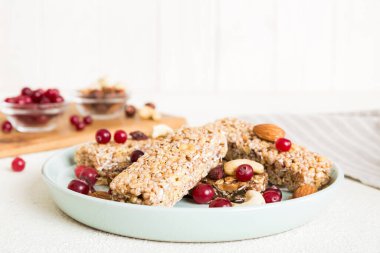 Arka planda çeşitli granola barlar var. Mısır gevreği gofretleri. Yulaf, fındık ve böğürtlenli kahvaltı barları, yakın çekim. Süper yiyecek konsepti.