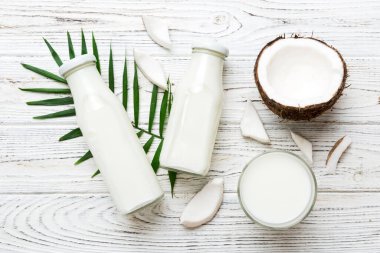 Beyaz tahta arka planda hindistan cevizi ürünleri. Sütsüz süt yerine içecek, yassı sağlıklı yiyecekler..