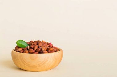 Fresh healthy peanuts in bowl on colored table background. Top view Healthy eating bertholletia concept. Super foods.