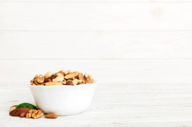 mixed nuts in bowl. Mix of various nuts on colored background. pistachios, cashews, walnuts, hazelnuts, peanuts and brazil nuts.