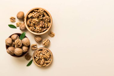 Ceviz çekirdeği yarım, ahşap bir kasede. Yakın plan, yukarıdan, renkli arkaplanda. Sağlıklı beslenme kavramı. Kopyalama alanı olan süper gıdalar.