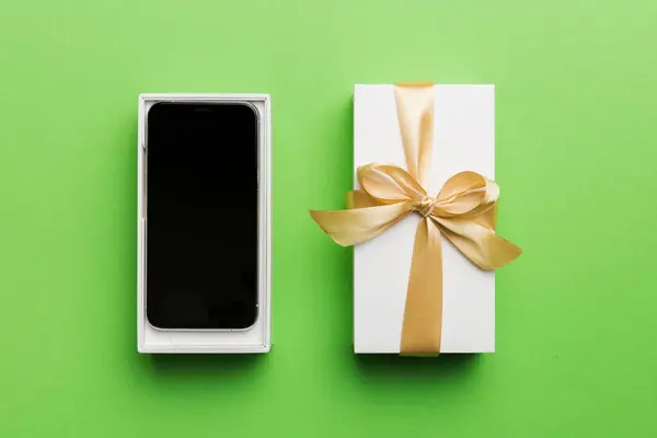 Ανοιγμένο Κουτί Δώρου Χρυσή Κορδέλα Και Smartphone Στο Φόντο Χρώμα — Φωτογραφία Αρχείου