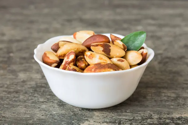 stock image Fresh healthy Brazil nuts in bowl on colored table background. Top view Healthy eating bertholletia concept. Super foods.