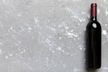 Renkli masada bir şişe kırmızı şarap. Düz konum, üst görünüm kopyalama alanı.