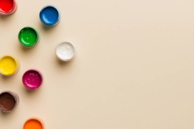 Renkli arka planda farklı renkte gagalı kavanozlar. Hobi resim. Boşluğu olan üst görünüm. Yaratıcılık için işyeri. ev öğretmenliği kavramı çizimi.