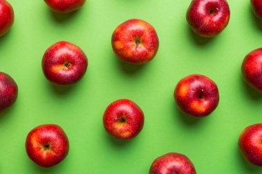 Renkli arka planda bir sürü kırmızı elma, üst manzara. Görüş üzerinde taze elma ile sonbahar deseni.