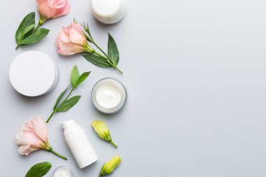 Kozmetik ürünleri ve ahşap arka planda güzel güller olan kompozisyon. Uzayı kopyala, düz yat.