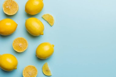 Renkli arka planda yeşil yapraklı taze limonlar, üst görünüm, metin için boşluk.