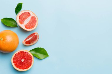 Renkli arka planda sulu greyfurt dilimli taze meyve greyfurdu. Üst Manzara. Uzayı kopyala yaratıcı yaz konsepti. Minimum düzlükte turunçgillerin yarısı kopyalama alanı ile yatar.