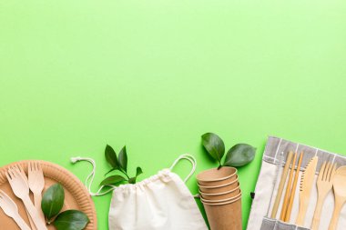 Açık beyaz masa arkaplanındaki boş, tek kullanımlık çevre dostu tabaklar, bardaklar, çatal bıçaklar. Üst Manzara. Biyo-çözünebilir el yapımı yemekler. Geri dönüşüm konsepti. Yakın plan..