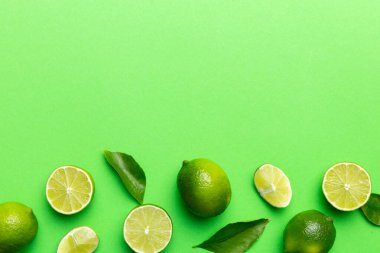 Yeşil yapraklı kireç meyveleri ve beyaz arka planda yarım dilim kesilmiş. Üst Manzara. Kopyalama alanı olan düz.