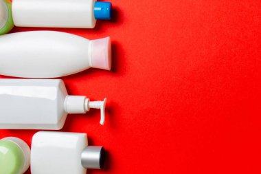 Plastik gövde bakımı şişesi düz kompozisyonu ve renkli arka plan boşluğuna kozmetik ürünler dizayn edilmişti. Beyaz Kozmetik kapları kümesi, kopya alanı ile üst görünüm.