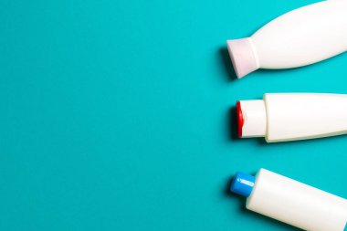 Renkli arkaplanda izole edilmiş Beyaz Kozmetik konteynırları seti, fotokopi alanı ile üst görünüm. Senin için bir grup plastik kaplar ve boş bir yer tasarladın..