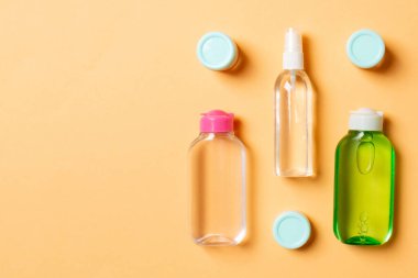 Kozmetik SPA marka modeli, fotokopi alanı olan üst görünüm. Renkli arka planda duran krema tüpleri ve kavanozları..