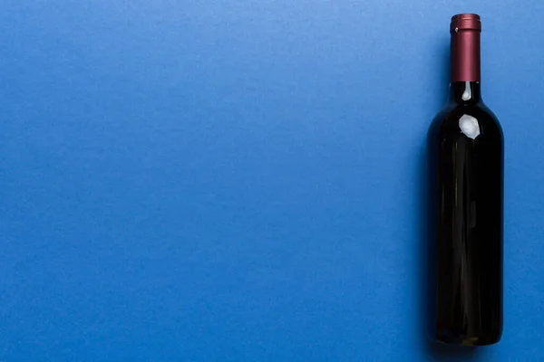 Een Fles Rode Wijn Gekleurde Tafel Vlakke Lay Bovenaanzicht Kopieerruimte — Stockfoto