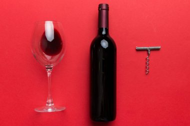 Tirbuşonlu düz kompozisyon, bir şişe şarap ve renkli masada zarif bir cam. Düz konum, üst görünüm kopyalama alanı.