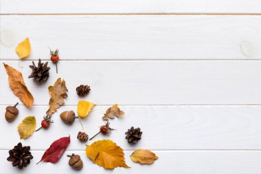Sonbahar kompozisyonu. Masadaki kurumuş yapraklar ve diğer tasarım aksesuarlarından oluşan desen. Düz yatış, üst görünüm.