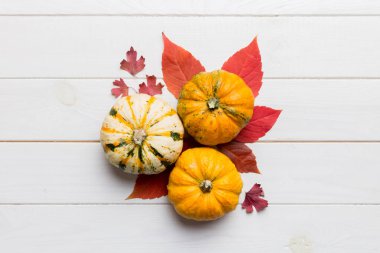Sonbahar kompozisyonu. Masadaki kurumuş yapraklar ve diğer tasarım aksesuarlarından oluşan desen. Düz yatış, üst görünüm.