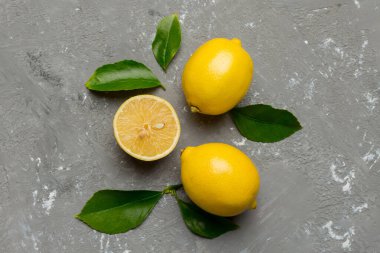 Renkli arka planda yeşil yapraklı taze limonlar, üst görünüm, metin için boşluk.