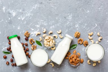Masa arkasında çeşitli vejetaryen süt bademi, kaju fıstığı seti ya da koleksiyonu. Vejetaryen bitkisi sütü ve malzemeleri, üst görünüm.