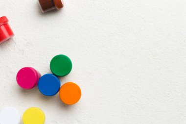 Renkli arka planda farklı renkte gagalı kavanozlar. Hobi resim. Boşluğu olan üst görünüm. Yaratıcılık için işyeri. ev öğretmenliği kavramı çizimi.