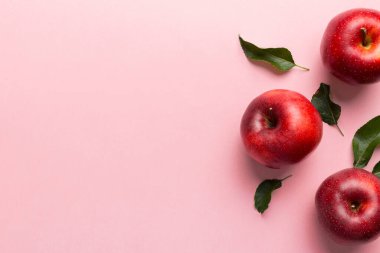 Renkli arka planda bir sürü kırmızı elma, üst manzara. Tasarım veya metin için kopyalama alanı olan taze elma görünümlü sonbahar deseni.