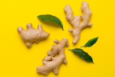 Renkli arka planda yeşil yapraklı kabın içinde zencefil tozu var. Üst görünüm düzlüğü.