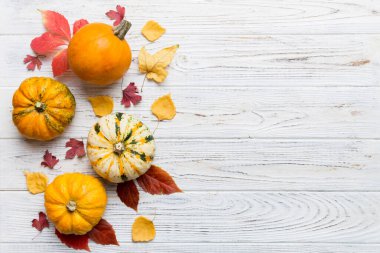 Sonbahar kompozisyonu. Masadaki kurumuş yapraklar ve diğer tasarım aksesuarlarından oluşan desen. Düz yatış, üst görünüm.