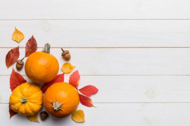 Sonbahar kompozisyonu. Masadaki kurumuş yapraklar ve diğer tasarım aksesuarlarından oluşan desen. Düz yatış, üst görünüm.