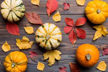 Sonbahar kompozisyonu. Masadaki kurumuş yapraklar ve diğer tasarım aksesuarlarından oluşan desen. Düz yatış, üst görünüm.