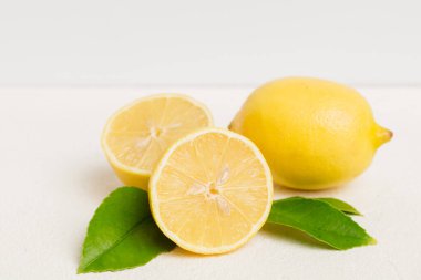 Renkli arka planda yeşil yapraklı taze limonlar, üst görünüm, metin için boşluk.