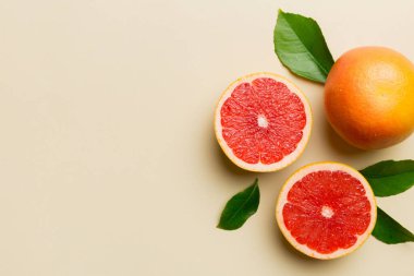 Renkli arka planda sulu greyfurt dilimli taze meyve greyfurdu. Üst Manzara. Uzayı kopyala yaratıcı yaz konsepti. Minimum düzlükte turunçgillerin yarısı kopyalama alanı ile yatar.