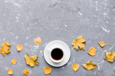 Renkli sonbahar kahve fincanı ve renkli yapraklarla bezenmiş düz bir kompozisyon. en üstteki görünüm.