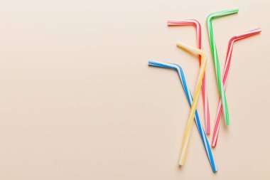 Renkli arka planda parti için pipet içmek. Yaz kokteylleri için renkli plastik tek kullanımlık pipetlerin en üst görüntüsü. kopyalama alanı olan meyve suyu için farklı pipetler.