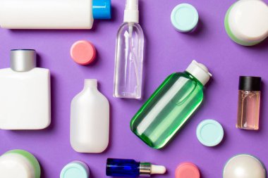 Plastik gövde bakımı şişesi düz kompozisyonu ve renkli arka plan boşluğuna kozmetik ürünler dizayn edilmişti. Beyaz Kozmetik kapları kümesi, kopya alanı ile üst görünüm.