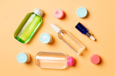 Kozmetik SPA marka modeli, fotokopi alanı olan üst görünüm. Renkli arka planda duran krema tüpleri ve kavanozları..