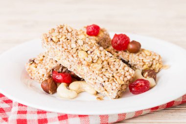 Arka planda çeşitli granola barlar var. Mısır gevreği gofretleri. Yulaf, fındık ve böğürtlenli kahvaltı barları, yakın çekim. Süper yiyecek konsepti.